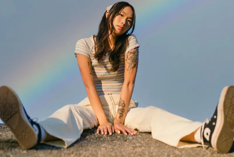 Woman sat on rocks wearing surf trousers